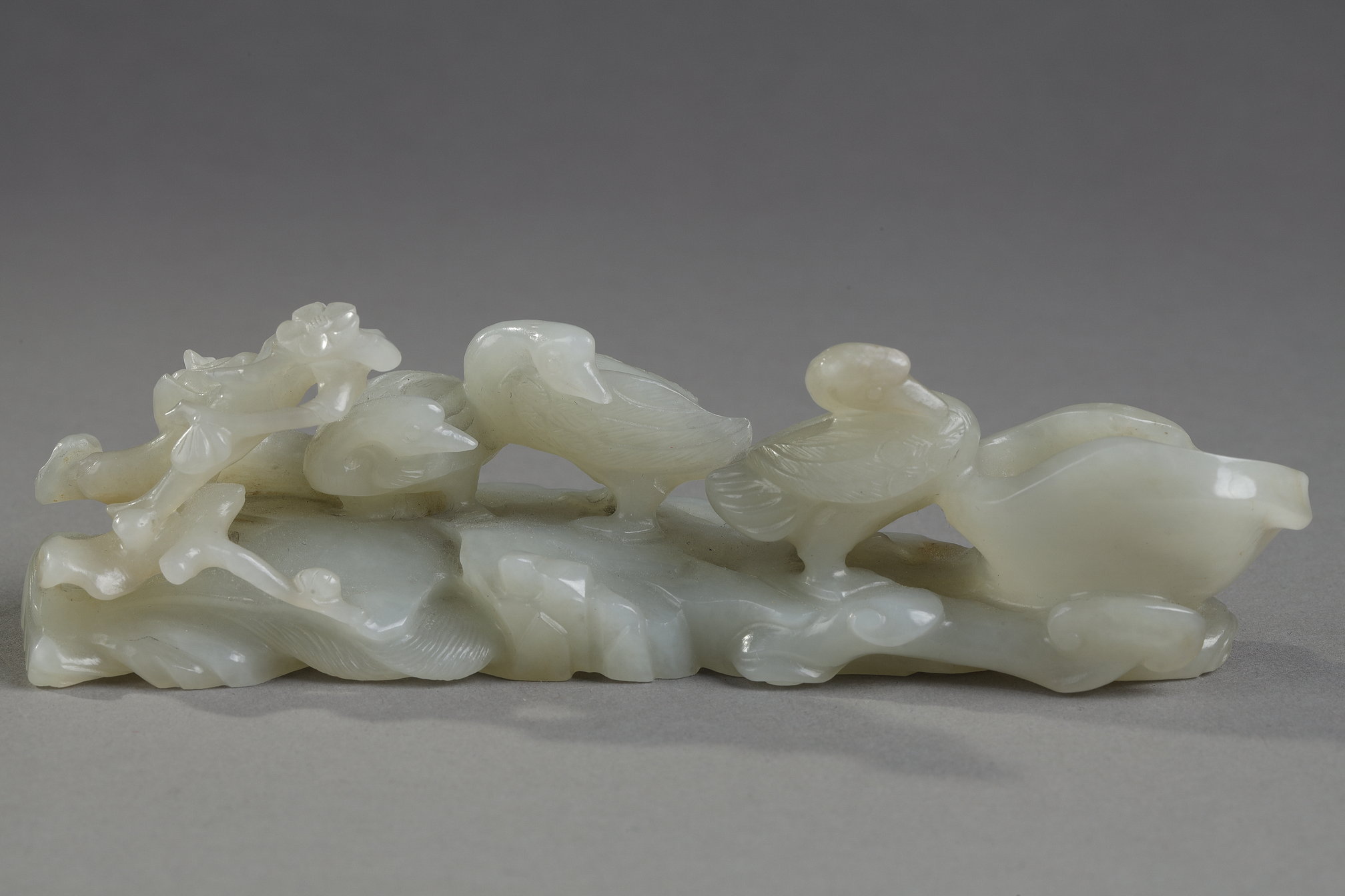 Nephrite celadon jade brush rest carved with three ducks next to a branch of prunus and also forming a water bucket - China 18/19em