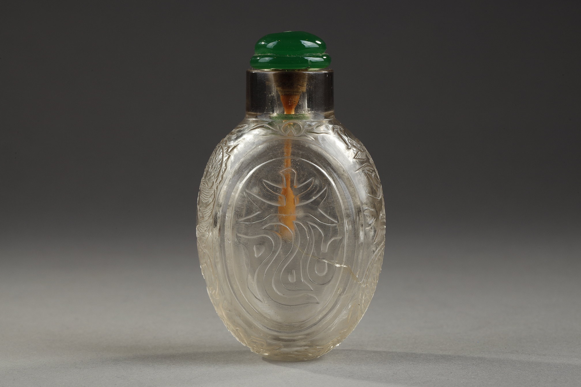 Chinese rock crystal snuff bottle of oval shape with auspicious characters and with dragons looking for the flaming pearl on the narrow sides - Probably the imperial workshops circa 1740/1860  
H 6,1cm