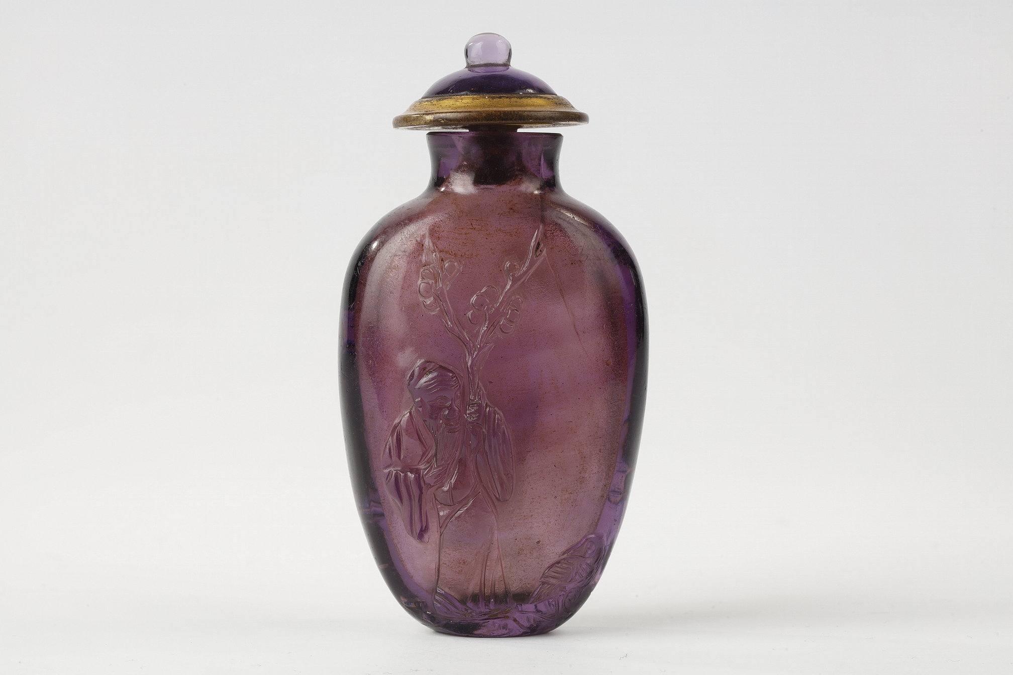 Glass snuff bottle perfectly imitating the amethyst decorated with a sage holding a prunus branch next to a duck and on the other side of a prunus overflown by a bird. 1780/1820