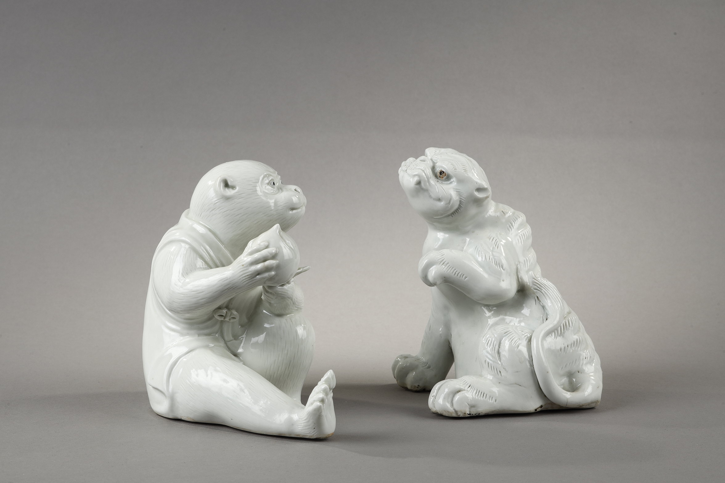 two white porcelain figures representing a monkey holding a longevity peach  and a tiger raising its paw - Japan Hirado kilns - 19th century 
H 14,5cm